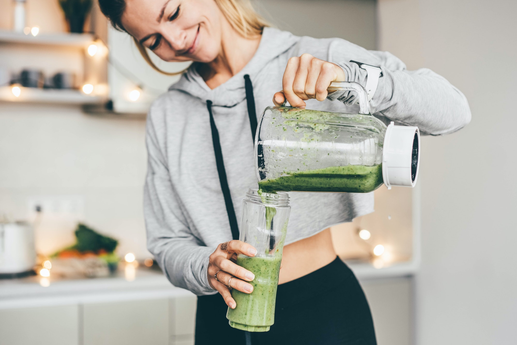 Young Woman Making Detox Smoothie At Home.